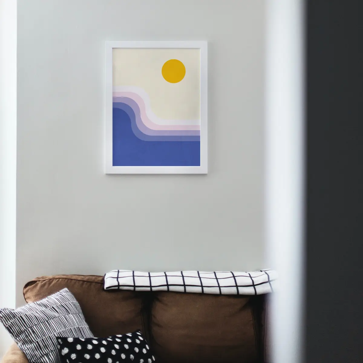 Mid-century colour block sunrise: a yellow sun over cream sky, lilac and pink bands, deep blue sea